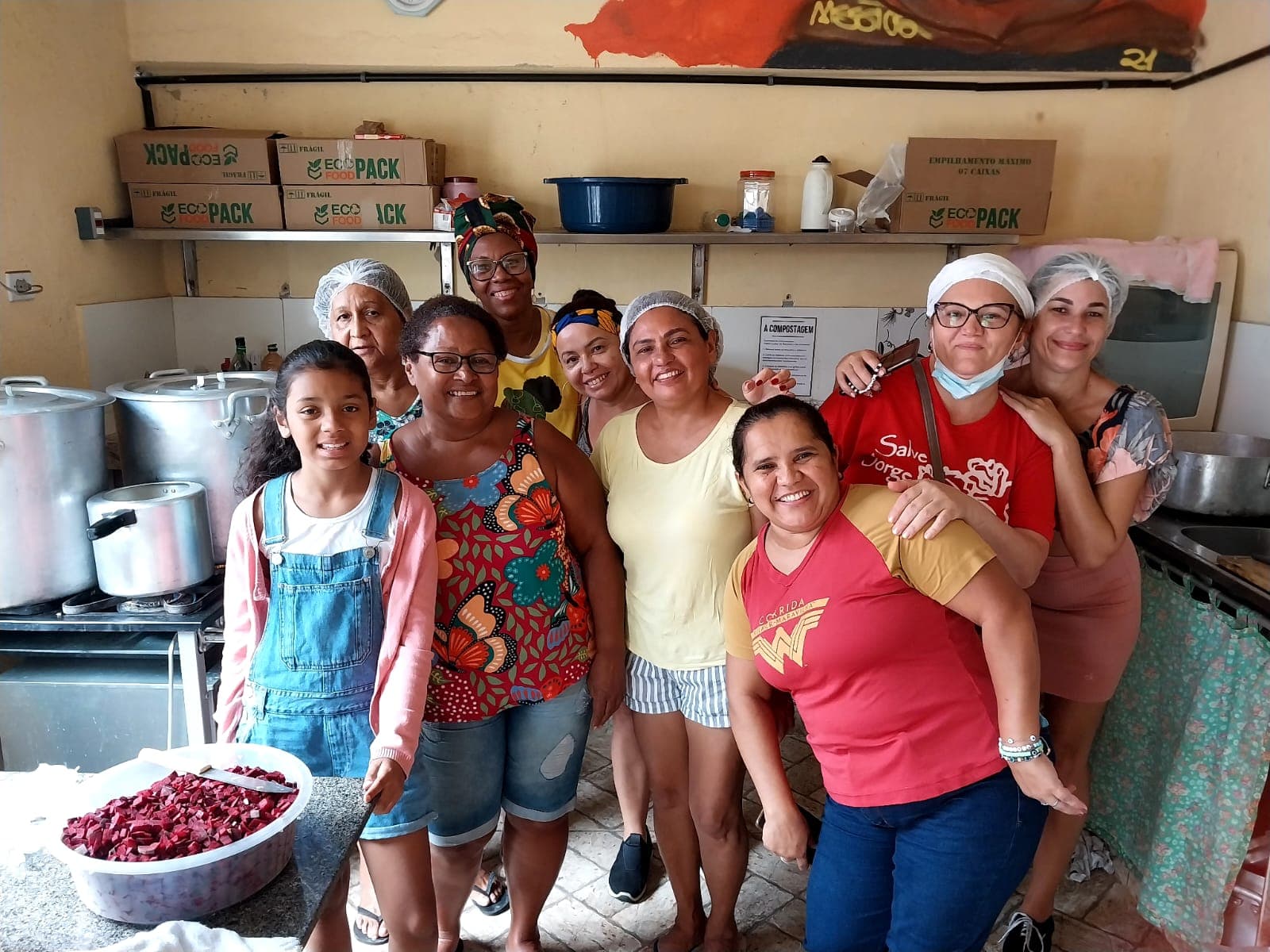 Voluntários rindo e cozinhando juntos